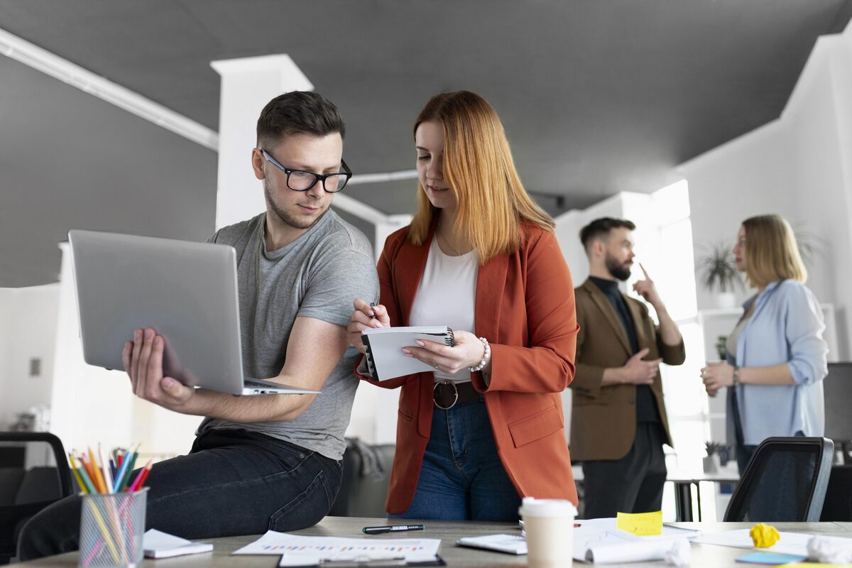 Sparringspartner statt Agentur: zwei Kollegen im Gespräch am Laptop Sparringspartner statt Agentur: zwei Kollegen im Gespräch am Laptop